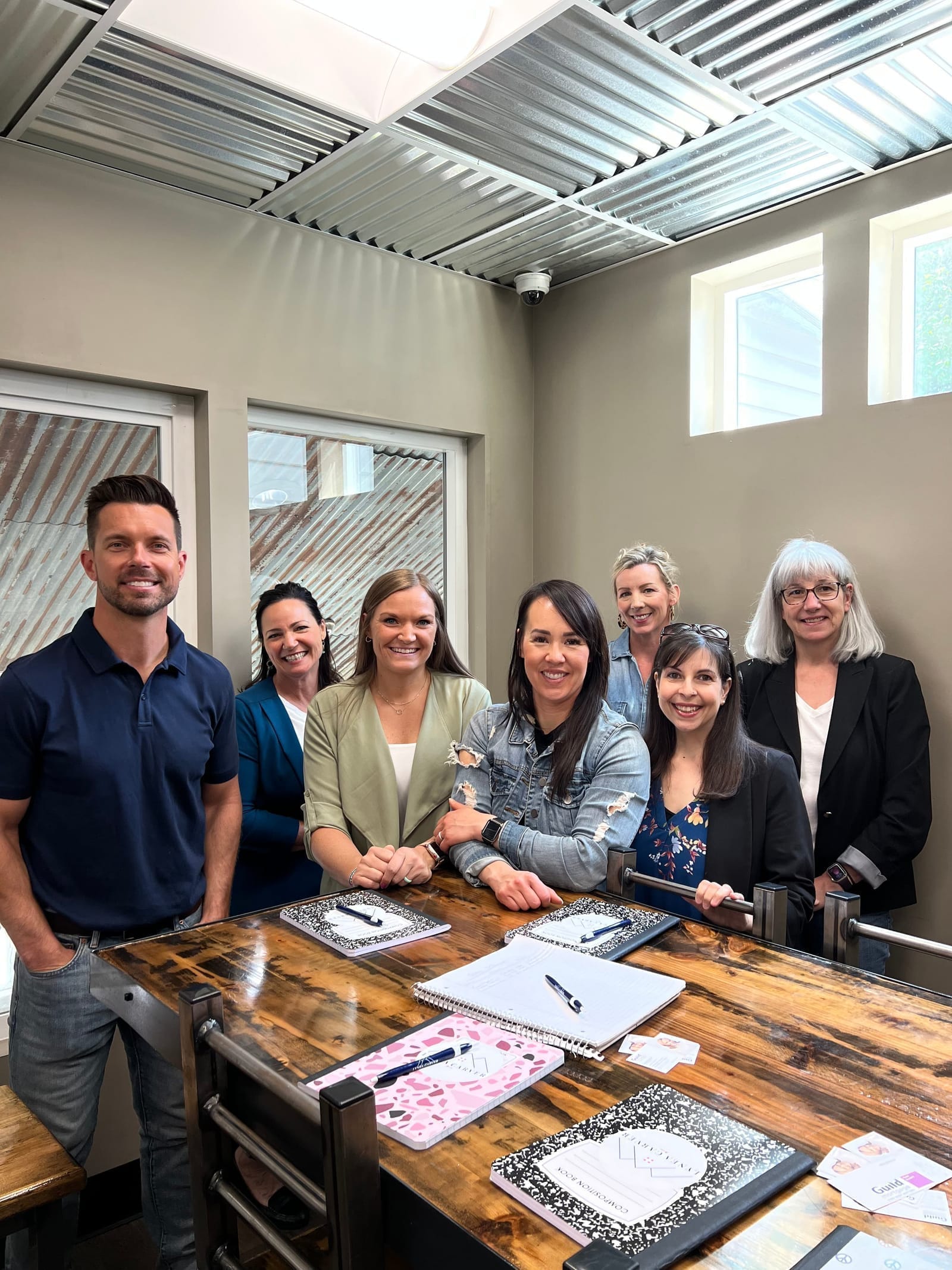 Lynea with a coaching cohort gathered around a wooden table